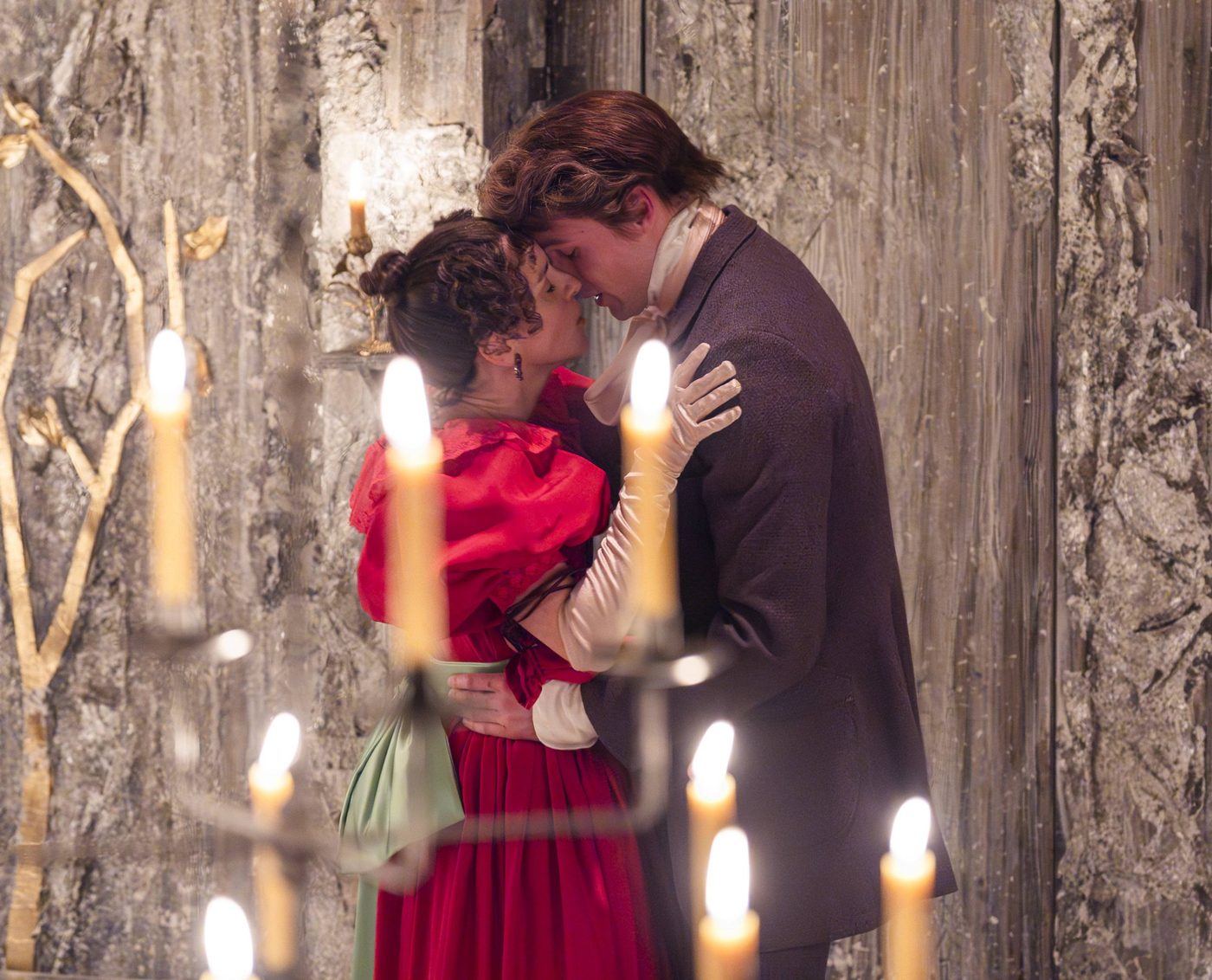 Natalie Klamar as Natalya and Stuart Thompson as Andrei in Three Sisters. Photographed by Tristram Kenton. Natalie Klamar as Natalya and Stuart Thompson as Andrei in Three Sisters. Natalya's hands are on Andrei's shoulders and his hands are on her waist. They look like they are about to kiss.