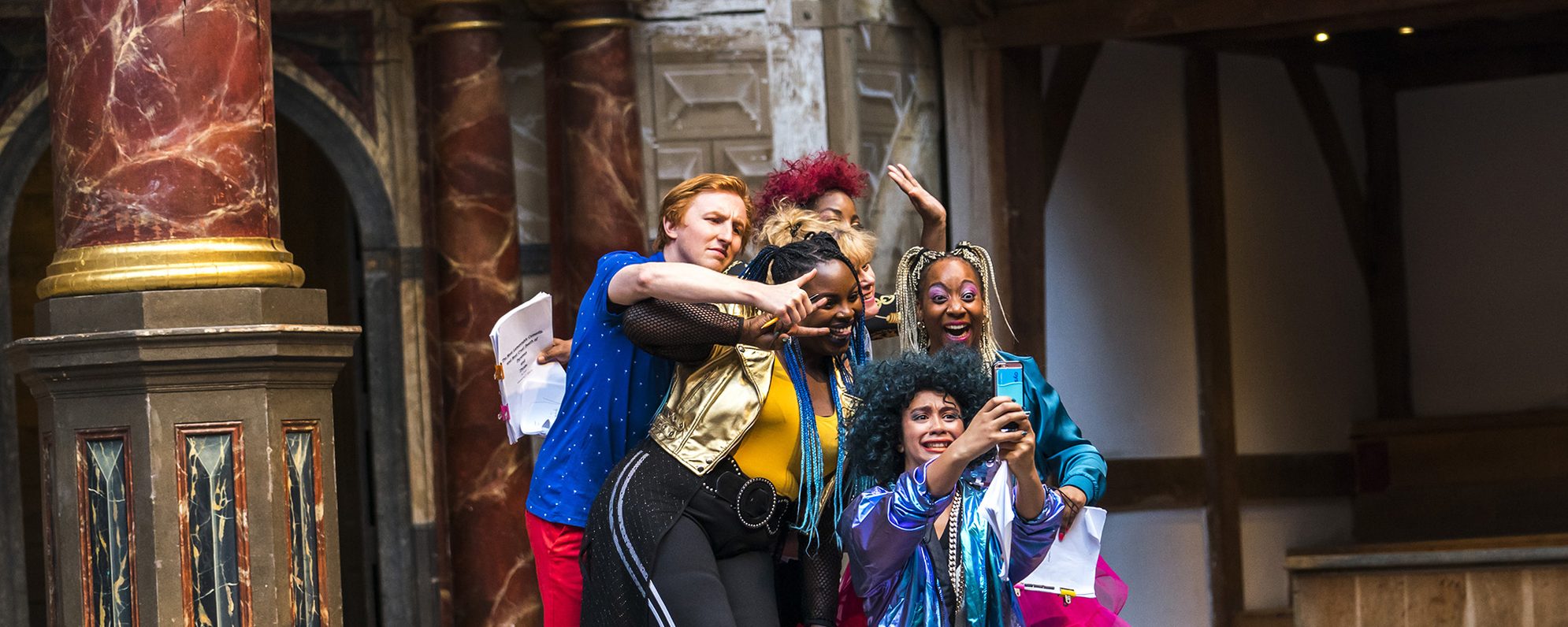A Midsummer Night's Dream 2019 Playing Shakespeare Tristram Kenton A group of actors huddle together to smile for a selfie on stage