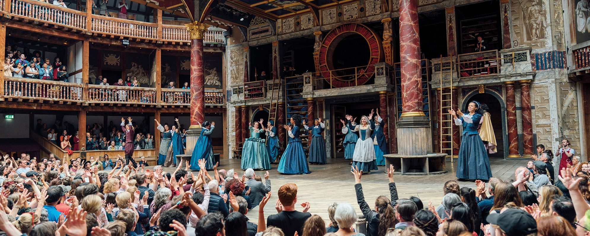 Research Collections Emilia Memory Week Such Stuff Blogs and Features Masthead The cast of 'Emilia' gather on stage with their arms in the air, the yard audience also have their arms in the air