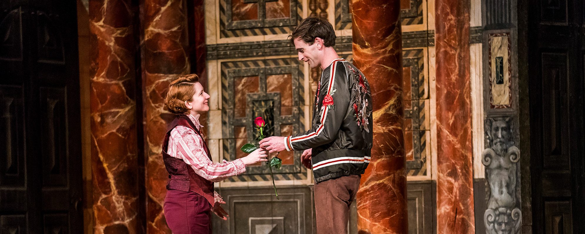 Gift Vouchers Orlando Rosalind As You Like It 2018 Shakespeare's Globe An actor hands another actor a red rose gift