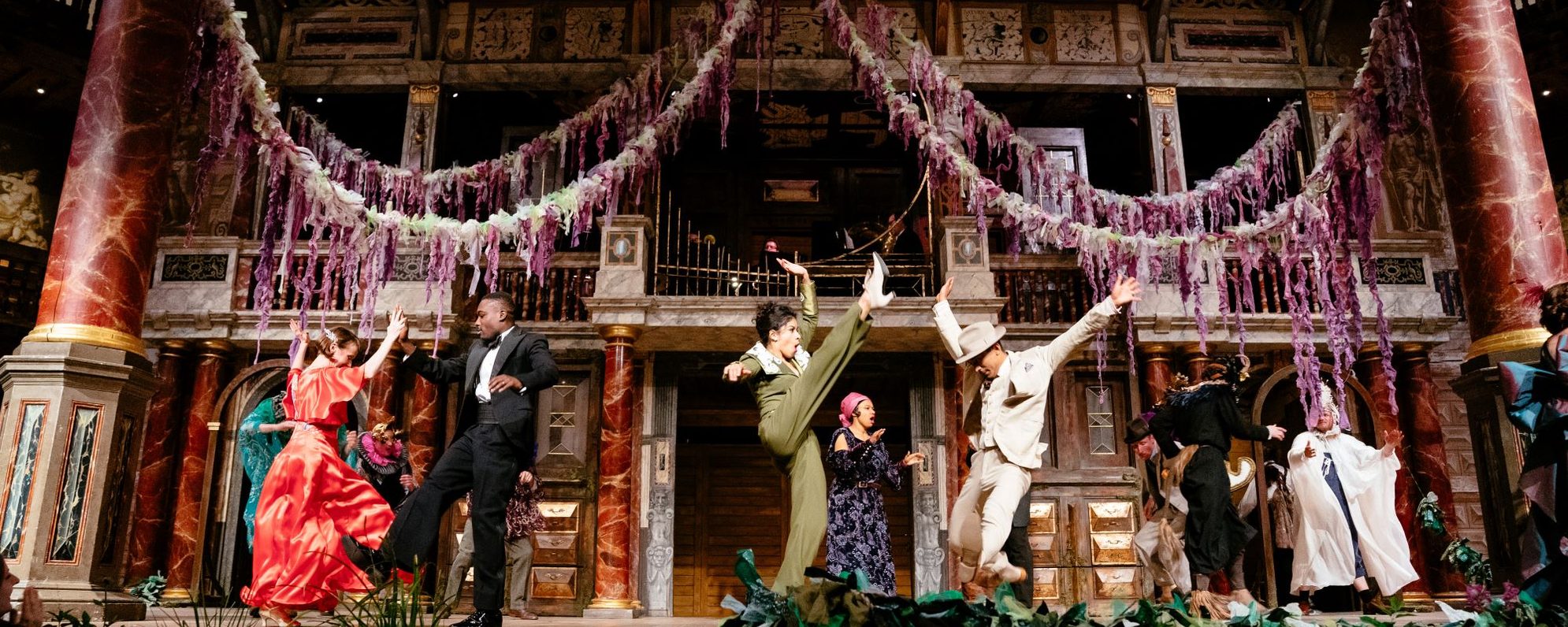 Globe Merry Wives_Audience_Helen Murray155 masthead A group of actors dressed in party clothes dancing on stage