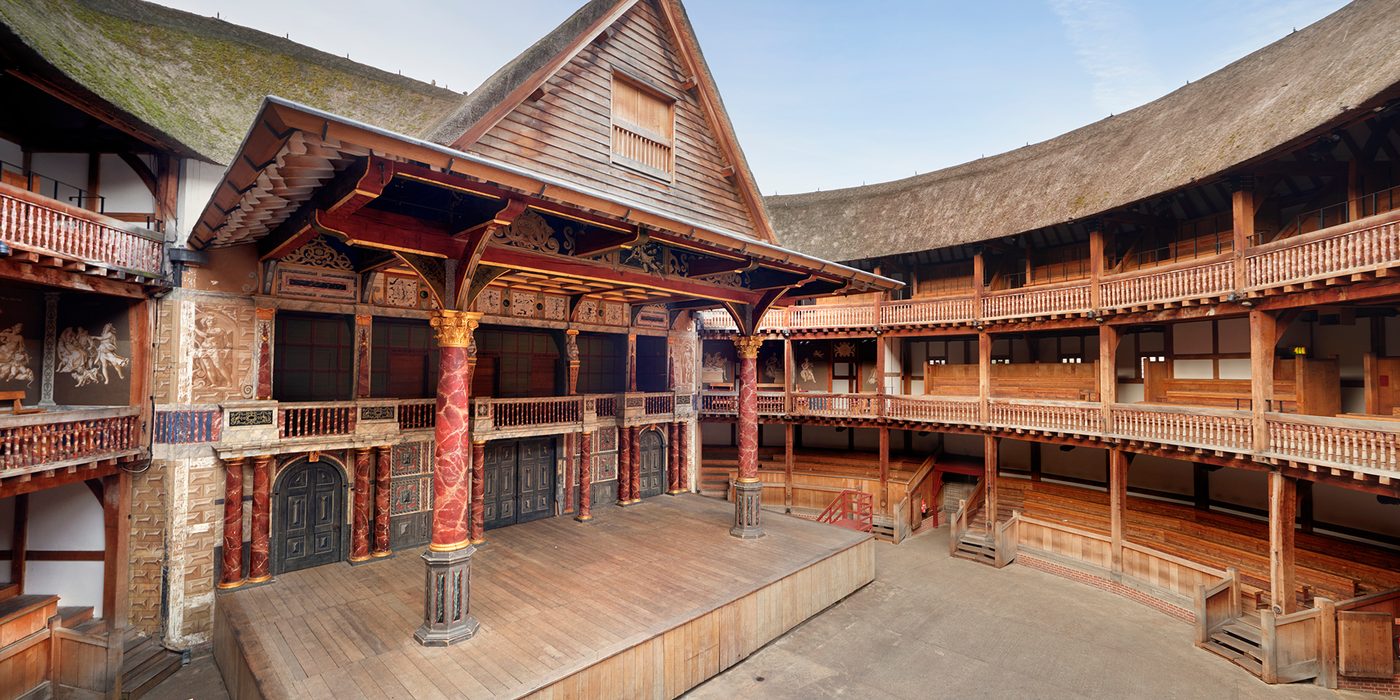 Globe Theatre Interior shot of a circular timber theatre, with a wooden thrust stage, with two large pillars holding up a thatched roof