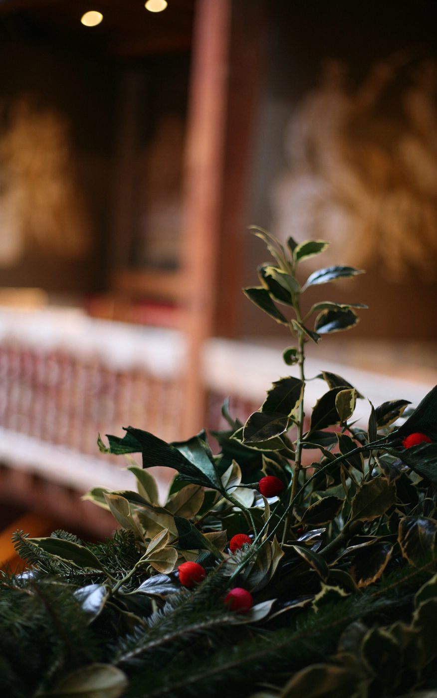 Holly Shakespeare's Globe Theatre Christmas 2020 A close up of a holly wreath wrapped around wooden banisters.