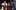 Kathryn Hunter Richard III Shakespeare's Globe An actor with a red crown and wearing a golden ermine cloak reaches to kiss the hand of another woman wearing black traditional Elizabethan dress.