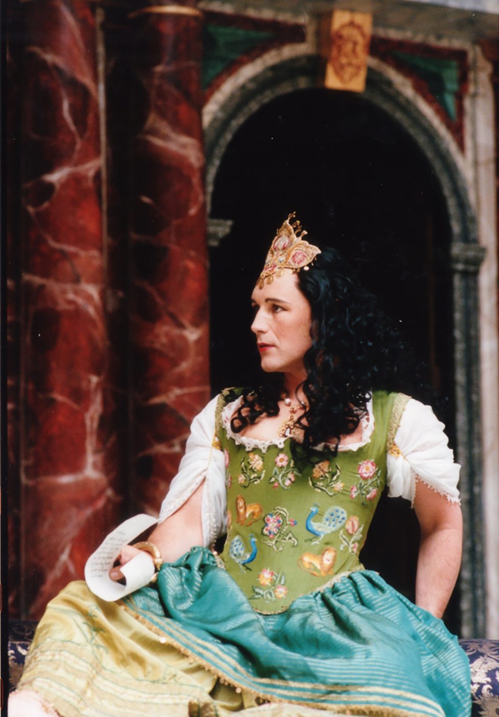 Mark Rylance Cleopatra Shakespeare's Globe A man wearing a green corset dress sits on the Globe Theatre stage.