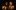 Tis Pity She's A Whore in the Sam Wanamaker Playhouse A woman and man stand in the glow of candlelight, the woman's hand touching the man's chin.