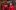 Philip Arditti Henry lI Part ll Globe 2019 Tristram Kenton An actor wearing a vivid red cloak, embroidered with golden lions, sits down, distraught, holding a crown out in their outstretched hand, as another actor looks on concerned behind them.