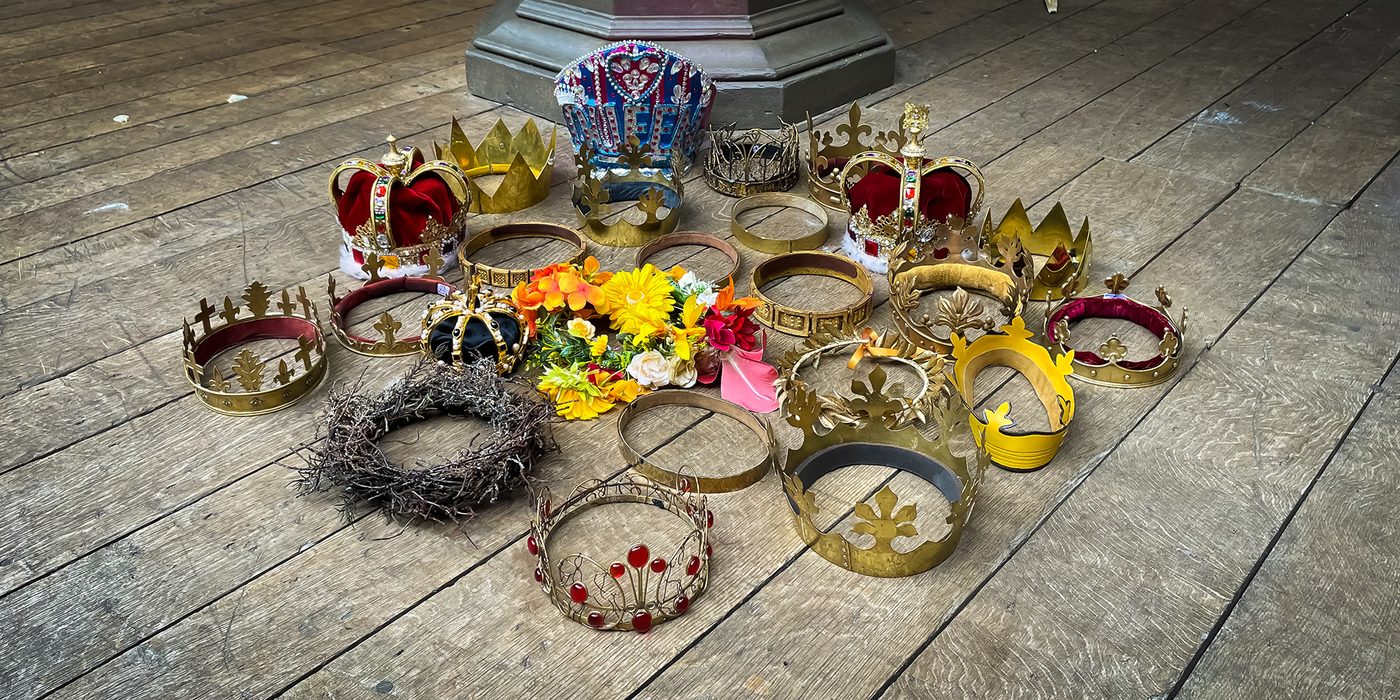 Shakespeare Crowns Globe Theatre Stage 2023 IMG_1955 Alex Jacobs FLUSH 2 A collection of crowns sit upon the wooden stage of the Globe Theatre.