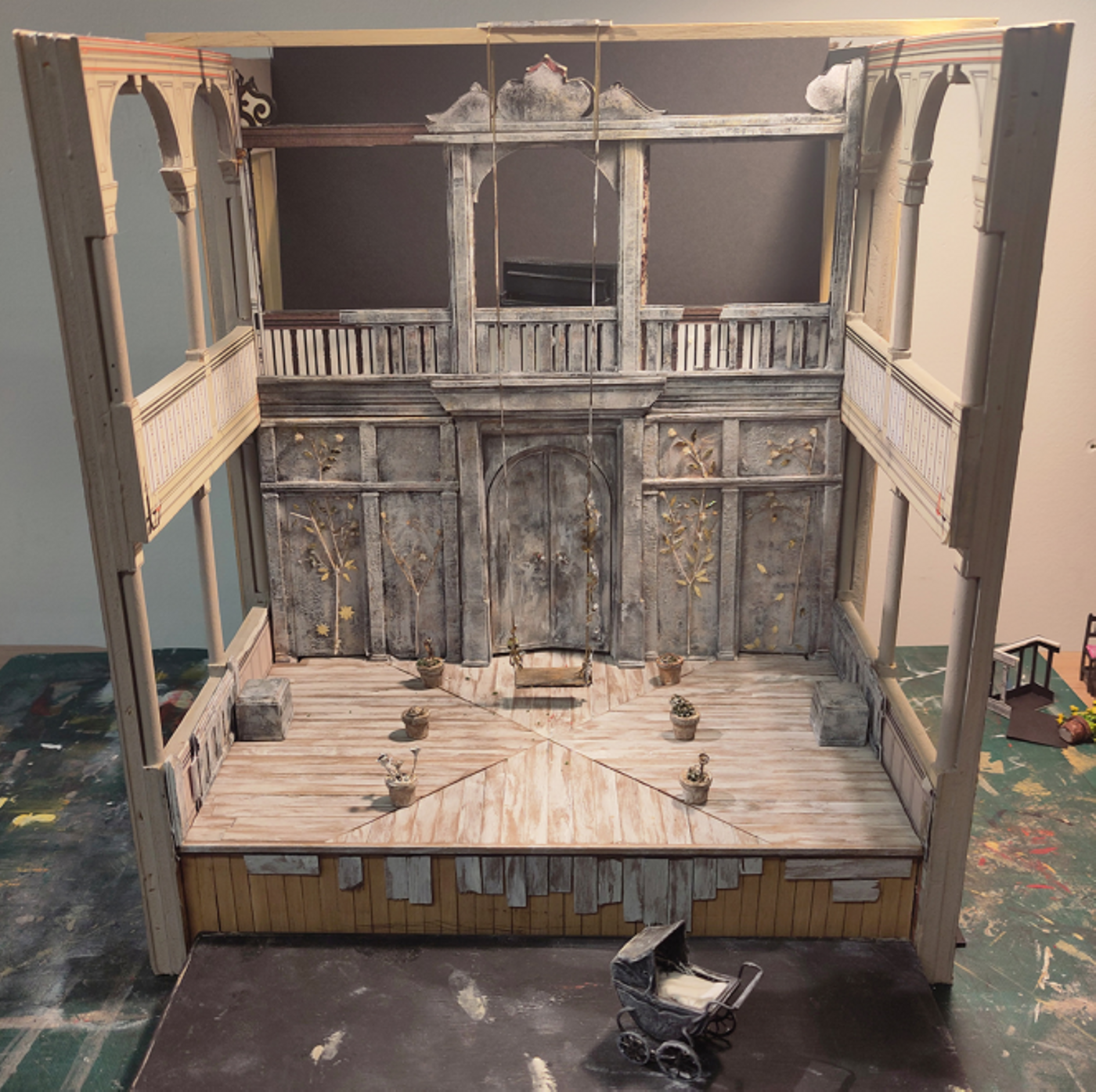 Model box set design of Three Sisters by Oli Townsend. Model box set design of Three Sisters by Oli Townsend. The model shows a relatively bare set. The walls and floor of the stage have been clad in silver birch, and on the back wall there are four silver birch trees depicted, with gold leaves. A swing has been lowered onto the stage from the heavens.