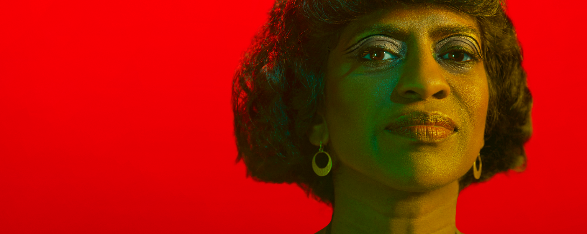 Antony&Cleopatra_Social+Website_2000 x 800 Photo of woman in front of a red background.