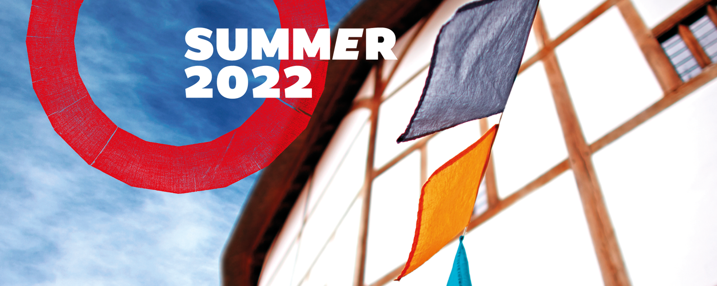 Summer 2022 Shakespeare's Globe Blog Masterhead Coloured flag bunting waves in the wind outside a white building set against a blue summer sky