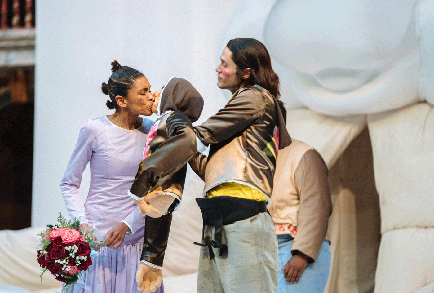 THALISSA-TEIXEIRA-as-KATHARINA-and-ANDREW-LEUNG-as-PETRUCHIO-in-The-Taming-of-the-Shrew-at-Shakespeare's-Globe-(c Thalissa Teixeira as Katharina holds flowers and kisses a puppet held by Andrew Leung as Petruchio. Photography by Helen Murray.